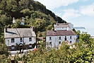 The former Temperance Hotel (Old Mill)  with Bucks Cliff Hotel as seen from the coast path - Hartland Point in the distance